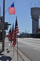 USA flags using sidewalk space Brainerd historic tower